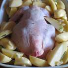 Выложить курицу грудкой вниз на противень ,смазанный оливковым маслом,выложить картофель и запекать в разогретой до 195 ° С  30 минут.Затем курицу перевернуть и запекать 30 минут.Увеличить температуру до 220 ° с и запекать ещё 20 минут.

