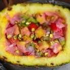 В ананас выложить фрукты,полить клубничным соусом и посыпать рубленными фисташками.Приятного аппетита:))