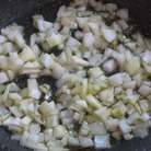 Лук мелко порезать. На сковороде разогреть оливковое масло и пассеровать лук несколько минут.