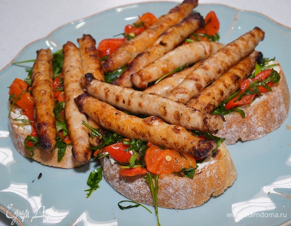 Брускетты с колбасками, сладким перцем и руколой 