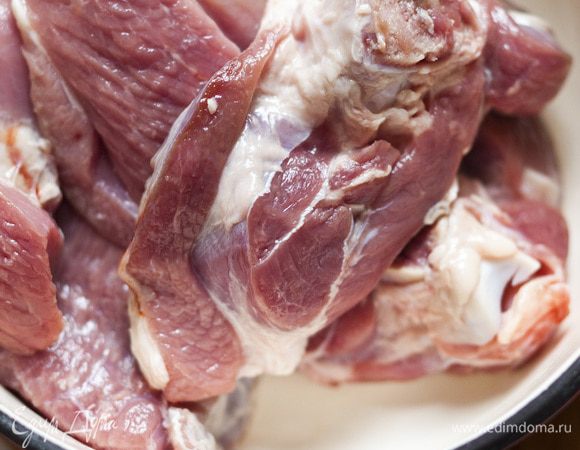 В большой кастрюле разогреть растительное масло и обжарить в нем куски баранины со всех сторон.