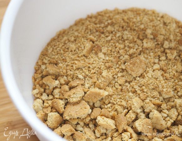 Печенье измельчить при помощи кухонного комбайна или поместить в полиэтиленовый пакет и поколотить скалкой.