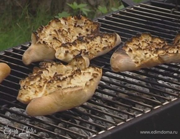 Разломать или разрезать каждую булку вдоль пополам, но не до конца и положить мякотью на гриль, чтобы она зажарилась.