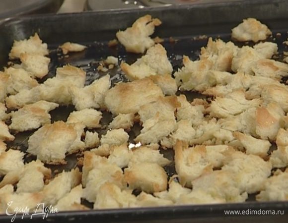 Приготовить крутоны: срезать с хлеба корку, поломать его на небольшие кусочки, сбрызнуть оливковым маслом и запекать в духовке 7–8 минут.