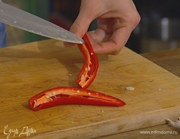 Перец чили, удалив семена, нарезать кусочками.