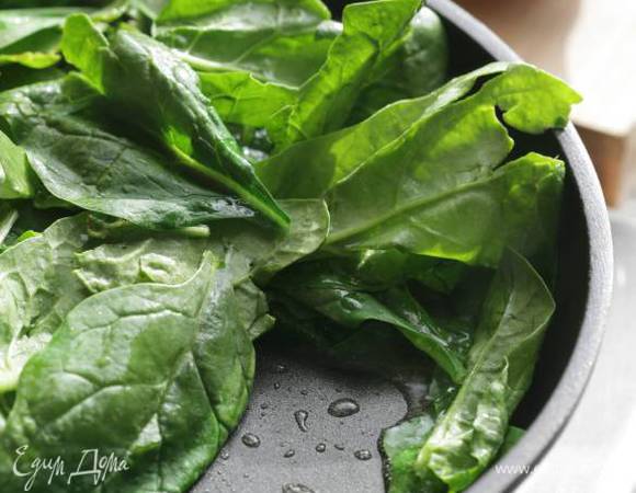 Разогреть в глубокой сковороде оливковое масло, выложить шпинат, посолить и поперчить, перемешать, накрыть сковороду крышкой и готовить 1‒2 минуты.