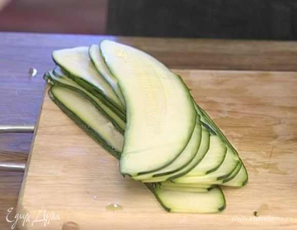 Цукини, не снимая кожуры, нарезать вдоль тонкими длинными пластинками.
