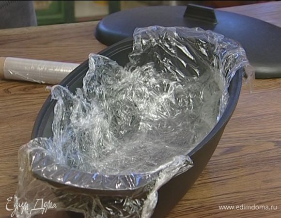 Выстелить дно и бока глубокой продолговатой формы пищевой пленкой, так чтобы края пленки свисали.