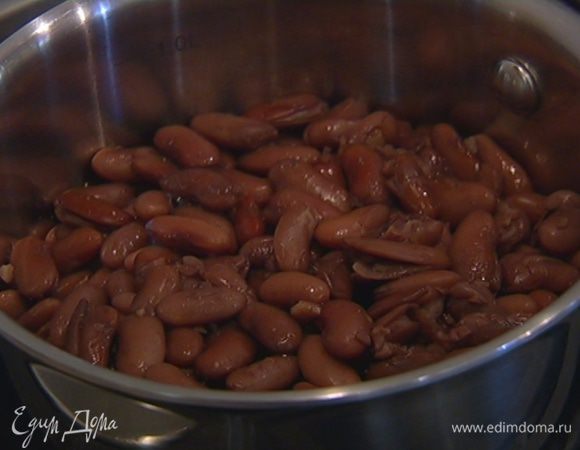 Фасоль замочить на ночь в большом количестве воды с содой, затем промыть, залить холодной водой и отварить согласно инструкции на упаковке. 