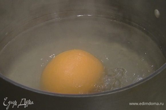 Вскипятить в небольшой кастрюле воду, опустить в нее апельсин и варить его 10–15 минут.