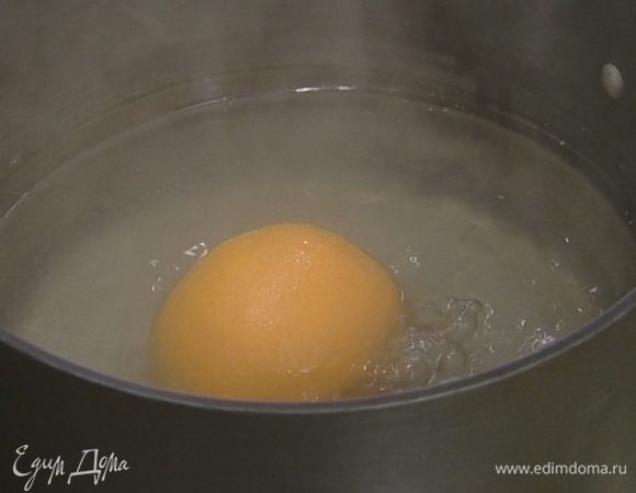 Вскипятить в небольшой кастрюле воду, опустить в нее апельсин и варить его 10–15 минут.