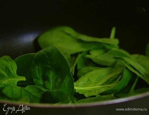 Разогреть в сковороде оливковое масло и прогревать шпинат около минуты, затем посолить и поперчить.