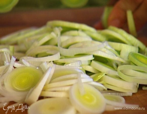 Светлую часть лука-порея нарезать тонкими кольцами. 