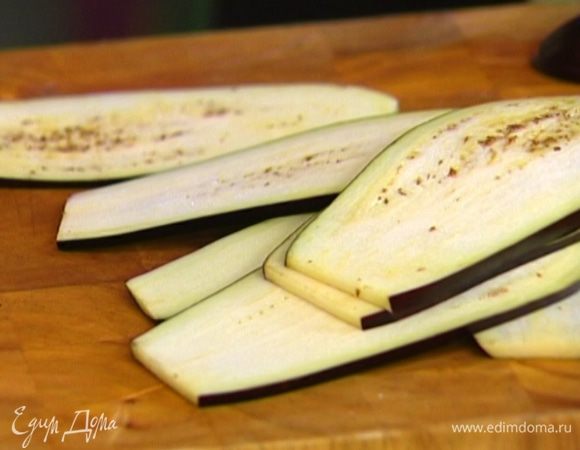 Баклажан нарезать вдоль тонкими ломтиками и обжарить на гриле с двух сторон.