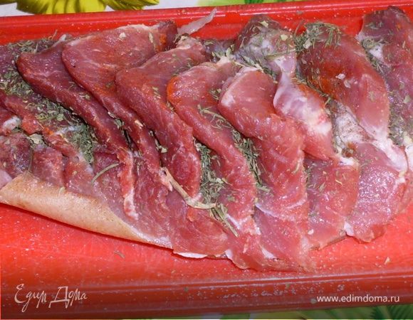 У меня был кусок свинины с кожицей. Я разрезала его на равные дольки не прорезая при этом кожу.
Каждый ломтик обильно посыпала сухими травами, посолила, поперчила.
