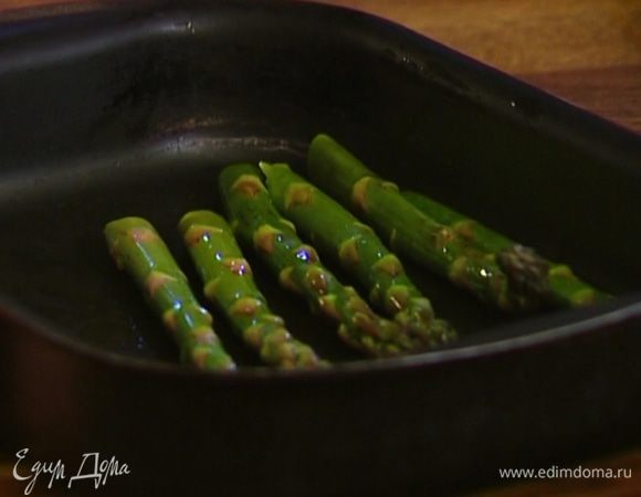 Спаржу выложить в глубокий противень, сбрызнуть оливковым маслом и отправить на 3–4 минуты под гриль.