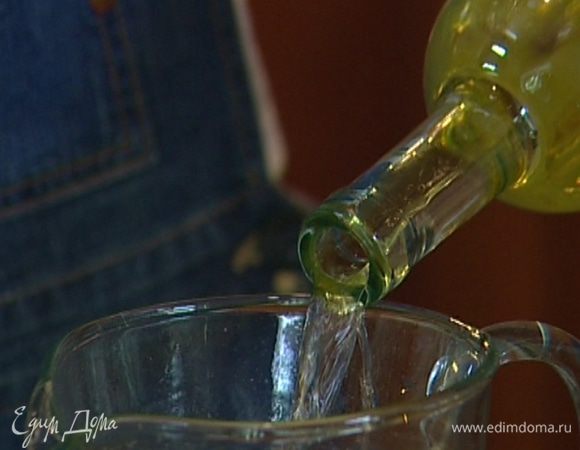 В большой кувшин выложить немного льда и влить вино.