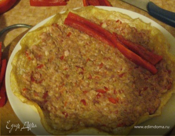 На присыпанную сторону блинчика по всей его поверхности, отступив от края по 1 сантиметру, ровным слоем выложить фарш, а на него с одной стороны выложить брусочки перца. Аккуратно свернуть рулетики.
