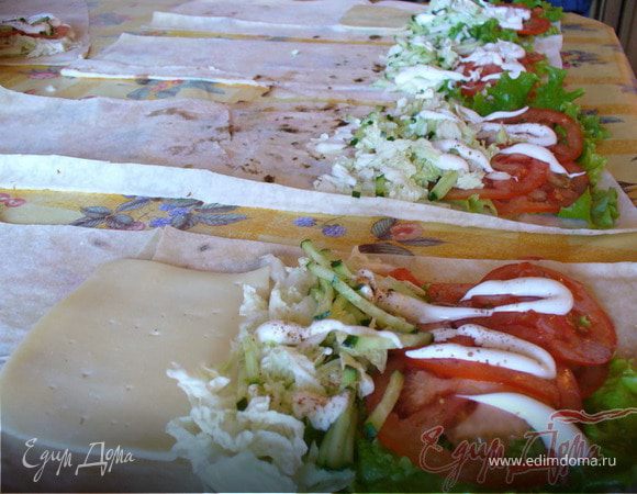 Лаваш разрезать ножницами на 4 полосы. 
Выложить салат, помидоры, огурцы, капусту. Овощи слегка посолить и поперчить. Положить тонкие пластинки сыра.
Индейку промокнуть от лишнего жира салфеткой, нарезать тонкими полосочками, добавить к овощам.
Капнуть немного сметаны в качестве соуса.