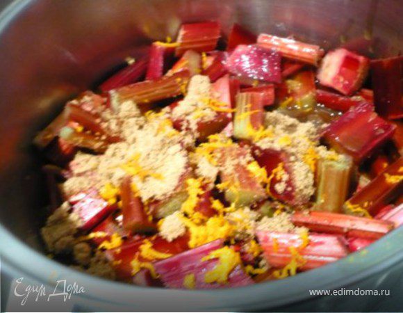 Ревень помыть, порезать крупными брусками (около 7 см).  Положить в кастрюлю,  добавить сок и цедру апельсина, присыпать половиной сахара (50 гр.). Накрыть крышкой и довести до кипения на маленьком огоне. Снять крышку и потомить еще минуты 3.  Переложить в жаростойкую посуду ровными слоем. 
