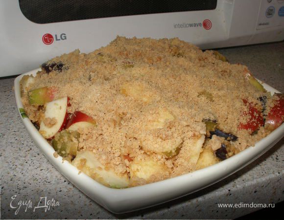 Выкладываем фрукты в подходящую для микроволновки посудину и пересыпаем двумя третьими частями карамельной крошки.Равномерно распределяем пересыпанные фрукты, сверху выкладываем остатки крошки и разравниваем.