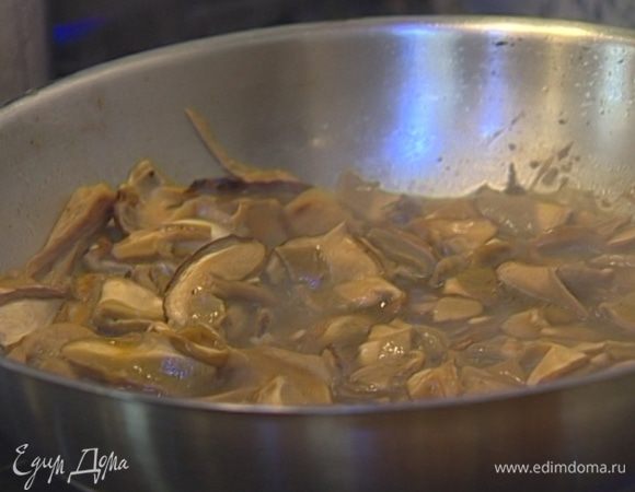 Воду, в которой были замочены грибы, процедить через сито, выстеленное бумажным полотенцем, добавить в сковороду и тушить грибы 20 минут. 