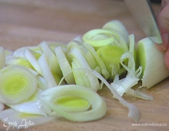 Светлую часть лука-порея нарезать наискосок тонкими кольцами. 