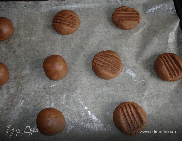 Духовку разогреть до 180С. Противень застелить пергаментом, смазанным маслом. Тесто разделить на равные части. Из кусочков теста скатать шарики, разложить их на противне на расстоянии друг от друга, чтоб они увеличились в размере, не мешая друг другу. Каждый шарик примять вилкой- сделать рельефный рисунок. Выпекать 15-20мин.