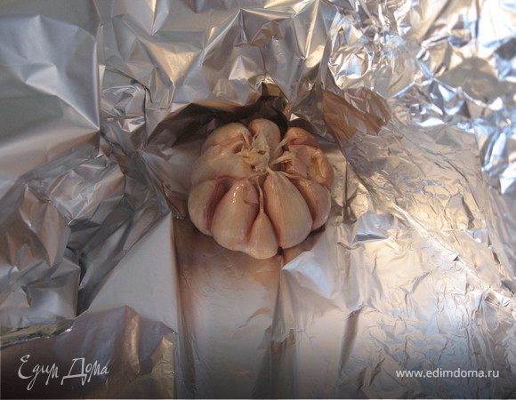 Головку чеснока очистить от верхнего слоя шелухи (молодой чеснок чистить не нужно) смазать маслом, завернуть в фольгу, запечь в духовке при 200 градусах до мягкости (40 минут). Остудить. Затем очистить чеснок от кожуры, размять в пасту, смешать с соком и цедрой лимона, солью, перцем.