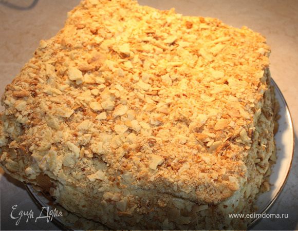 Готовые коржи выкладываем на ровную поверхность, чтобы они полностью остыли и еще в теплом виде обрезаем края, для придания одинакового размера. В большой емкости взбиваем масло комнатной температуры со сгушенкой, постепенно добавляя полностью остывший заварной крем. Каждый корж щедро промазываем кремом,когда кладем следующий - слегка прижимаем рукой.Намазываем кремом последний и обмазываем края. Обрезки коржей крошим рукой и обсыпаем торт со всех сторон.