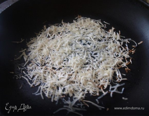 Пармезан используем потому, что он достаточно твердый и корзиночка хорошо будет держать форму. Более ажурными корзинки получаются если трем сыр на мелкой терке. Натертый сыр выкладываем на разогретую сухую сковороду, немного больше сыра нужно положить в середину, где будет дно корзиночки. 
