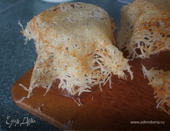 Когда сыр начал плавиться, аккуратно лопаточкой поддеваем наш коржик и надеваем на перевернутый стакан и слегка обжимаем (величина корзинок зависит от размера формы, на которой вы их формируете).