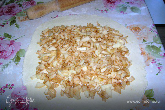 Раскатать тесто толщиной примерно 5 мм и положить сверху мелко нарезанные яблоки.
