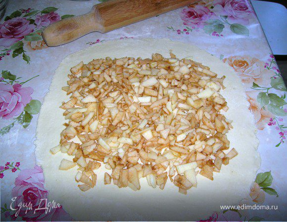 Раскатать тесто толщиной примерно 5 мм и положить сверху мелко нарезанные яблоки.