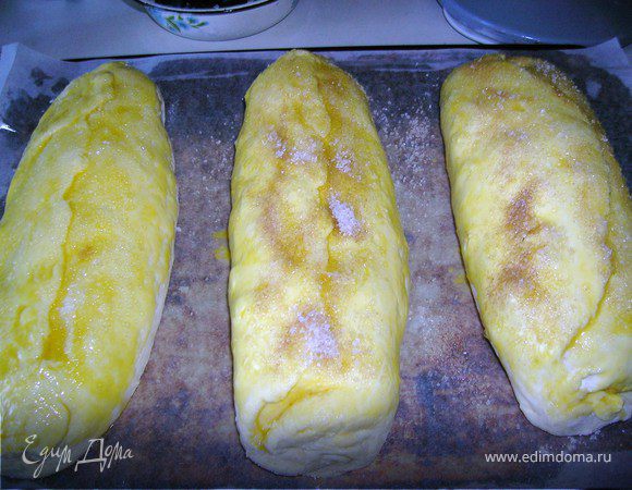 Выложить рулетики на лист и каждый сверху намазать желтком и посыпать сахаром.