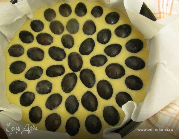Промойте ягоды и просушите(сливы разделите на две части и удалите косточку), распределите их сверху на жидкое тесто.