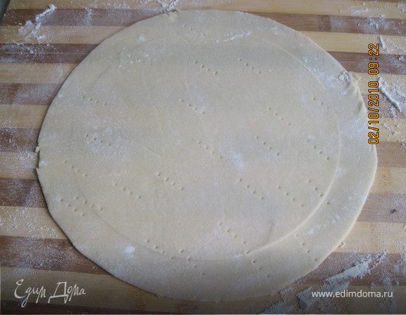 Раскатать тесто на посыпанной мукой поверхности и наколоть вилкой.  