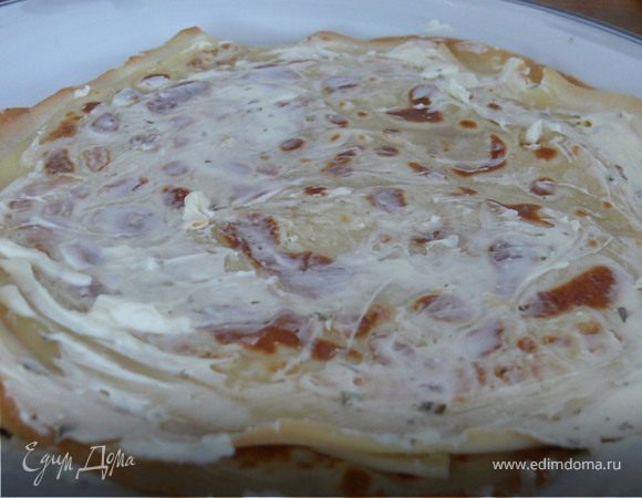 На тарелку положить 1-й блин, смазать творожным сыром