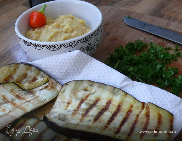 Баклажан порезать тонкими пластами(вдоль).Посолить, сбрызнуть оливковым маслом, пожарить.Я делаю на сковородке-гриль.Можно и на обычной, только масло не лить(достаточно того, что баклажаны в себя вобрали).Мелко порубить зелень.