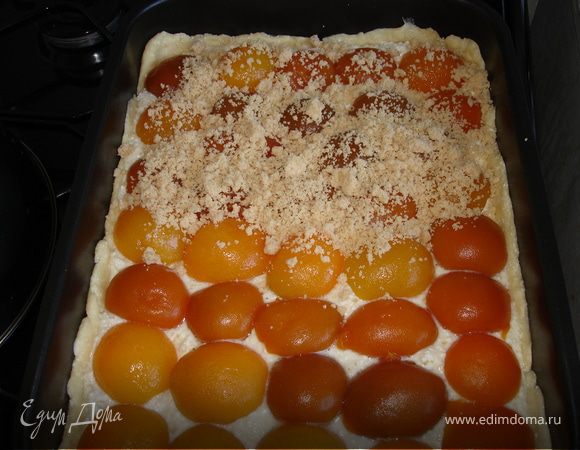 Для начинки творог смешать с манкой, которую я заменила на крупные овсяные хлопья, немного растёртые вручную, и сливками-если нужно, мне не понадобились: творог был не сухой, и я решила использовать оставшийся после приготовления теста белок. Белки отделить от желтков и взбить с сахаром, желтки с ванилином подмешать к начинке. Ввести взбитые белки. Начинку разровнять на тесте, разложить абрикосы, посыпать масляной крошкой: растереть сливочное масло с сахаром, мукой и корицей.