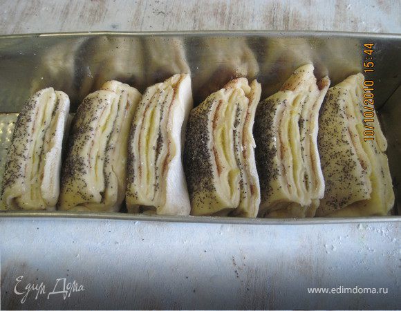 Уложите полоски в подготовленную форму срезом вверх. Полоски не будут лежать плотно - в форме нужно немного места для подъема теста, но постарайтесь уложить их так, чтобы они стояли. Не плотно накройте пирог и оставьте подняться в теплом месте на 30 - 50 минут, пока пирог не увеличится в двое.