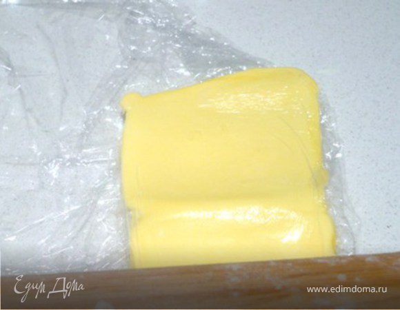 Каждый квадратик положить в пленку и, сначала немного побив  скалкой,  тонко раскатать. Остальные держать при этом в холодильнике, беря по одному, так как масло может начать таять и затруднить процесс. Можно  попробовать раскатывать сразу несколько , положив их  в пленку подальше друг от друга. Раскатанное масло положить обратно в холодильник. Если не можете легко «отодрать» пласты от пленки, из-за того, что масло подтаяло, положите в холодильник с прямо пленкой. Когда масло затвердеет, его будет легко достать.  
