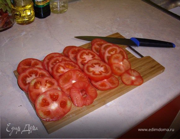 На разогретую сковороду, наливаем масло, и начинаем обжаривать рыбу. Пока рыба жариться, мы нарезаем кружочками помидоры, и мелко режем зелень.
