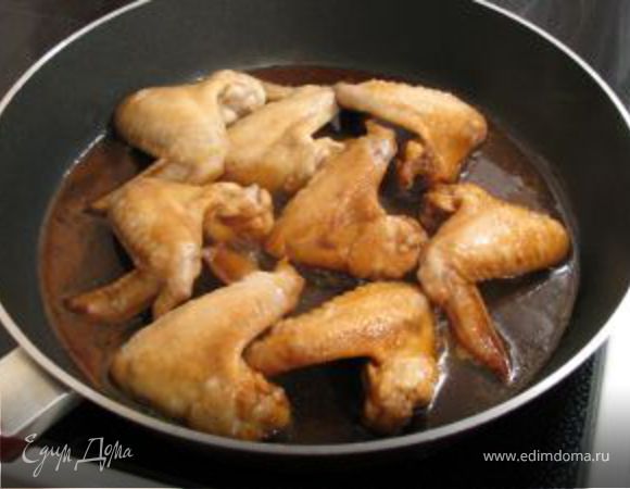Затем крылышки обжарить с двух сторон.
Добавить соус, в котором мариновались крылышки.
Жарить под крышкой в течение 15-20 минут.