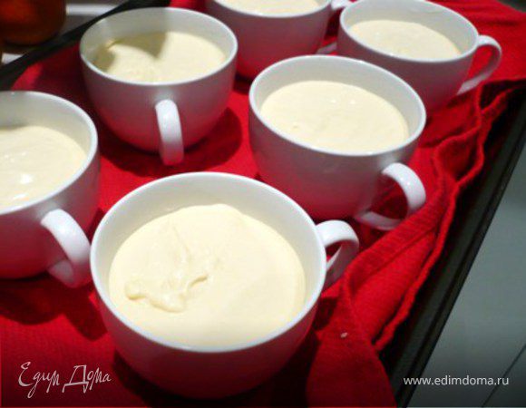 Дно глубокого подноса  или прямоугольной формы  для выпекания выложить кухонным полотенцем. Полотенце нужно для того, чтобы формочки не «елозили» по подносу, особенно когда поднос достается из духовки. На полотенце поставить  формы с десертом. Налить в поднос горячую воду так, чтобы вода почти доходила до середины форм с десертом.  Выпекать в разогретой до 150С духовке 20-25 мин  - крем должен “схватиться”.  Остудить и поставить в холодильник на 3-4 часа.