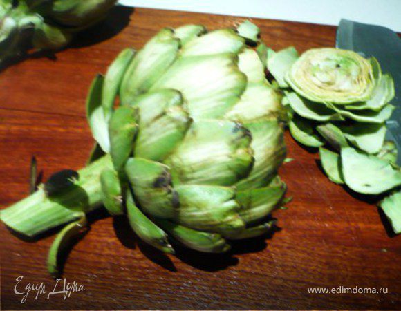 Почистить артишоки: сначала отрезать верхушку (около 2,5 см.). Ободрать верхние грубые листочки, пока не дойдете до мягких и нежных. Стебель почистить ножом или овощечисткой.  Очищенные артишоки сразу же опустить в воду с лимонным соком.  
