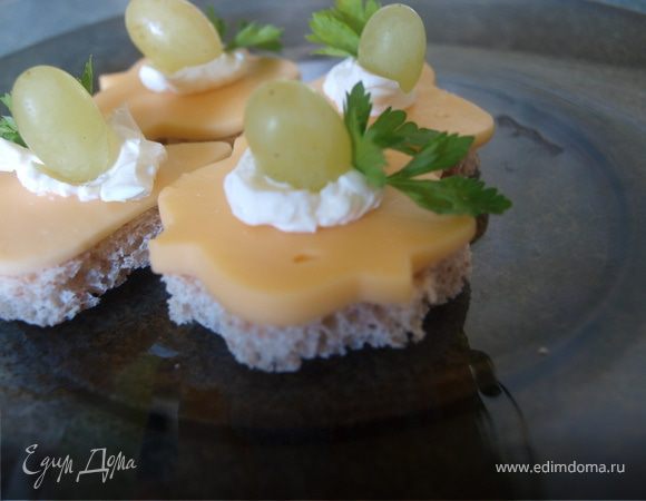 Дальше поступаем так: на хлеб немного сливочного сыра, сверху - такой же формы твердый сыр, на него немного сливочного сыра и ягодка винограда.
 Такие канапе прекрасно подходят к легкому вину.
 Используйте свою фантазию для приготовления таких канапе на свой вкус, удачи и приятного аппетита!