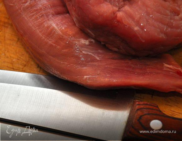 Свиные миньоны завернуть пленкой и отправить в морозилку на 30 минут.  Затем нарезать вырезку лепестками по 5мм толщиной.