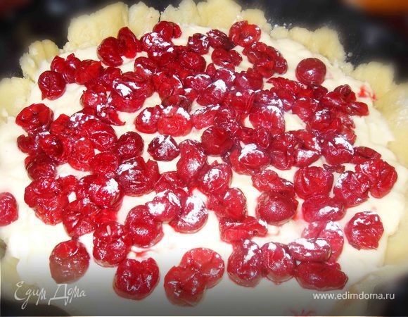 Тесто делим на 2 части. 
Большую часть теста равномерно распределяем по форме, делая небольшие бортики. На получившуюся основу выкладываем остывший заварной крем и вишни. Вишни чуть присыпаем сахарной пудрой. 