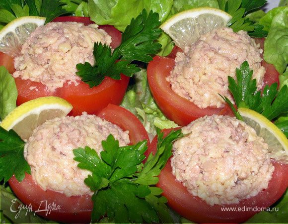 Сыр натереть на мелкой терке. Добавить печень трески и размять вилкой. Полученной массой наполнить помидоры. Если они большие, то - половинки помидор. Выложить на листья салата. Украсить зеленью. Приятного аппетита!